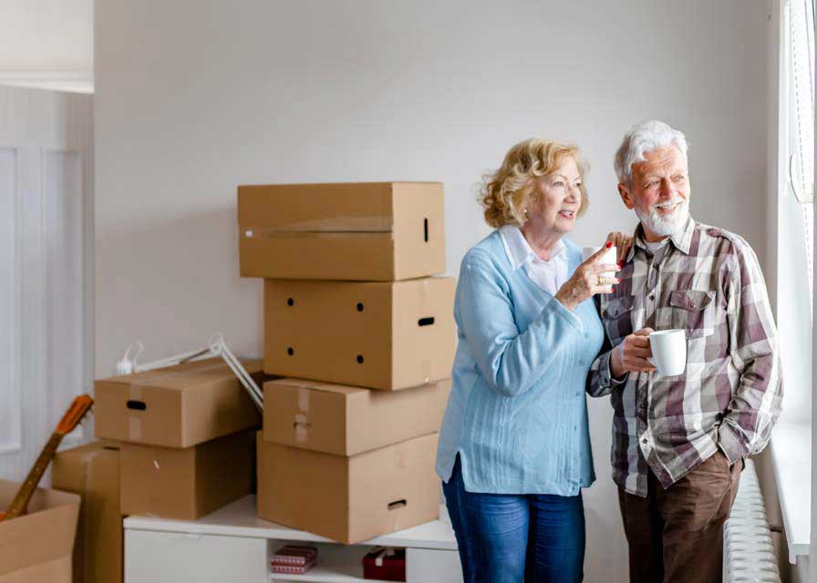 senior couple at moving day looking through the window