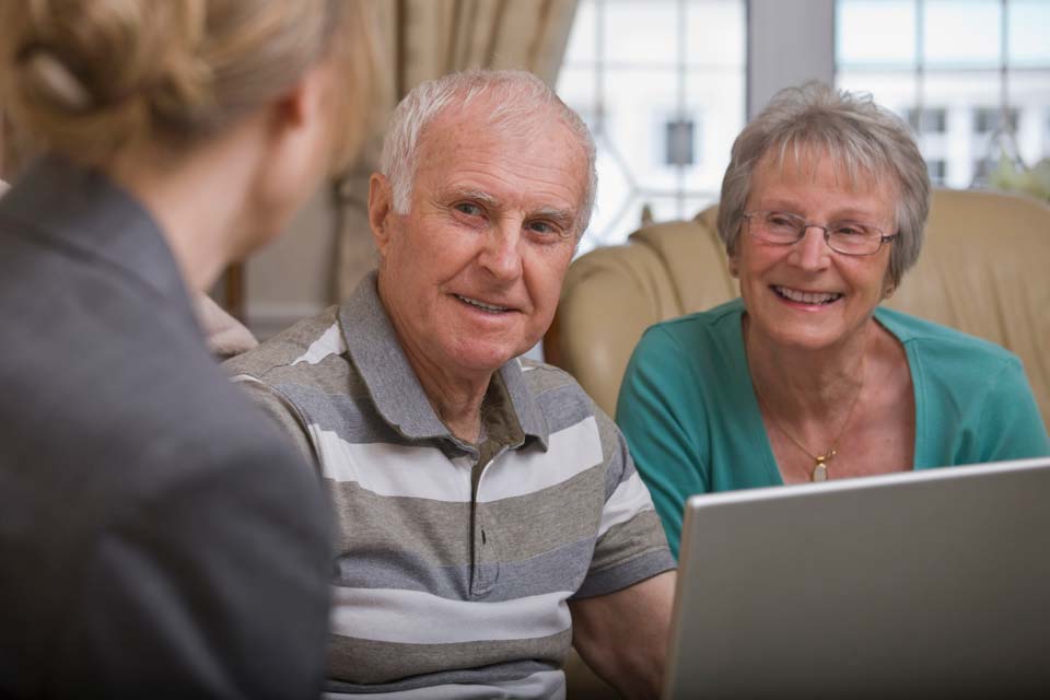 senior couple at home talking to an advisor