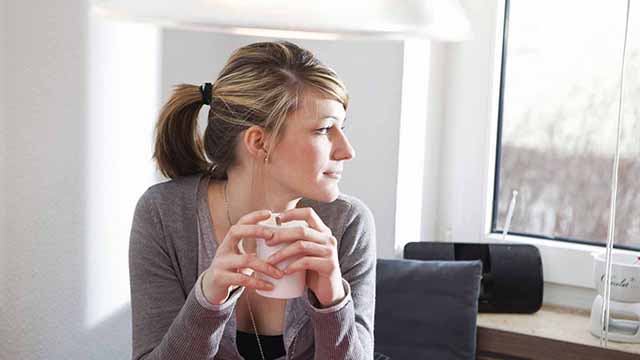 Woman drinking tea by her desk