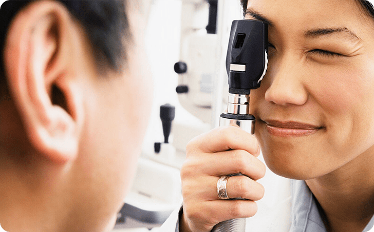 Optometrist examining eye of male patient