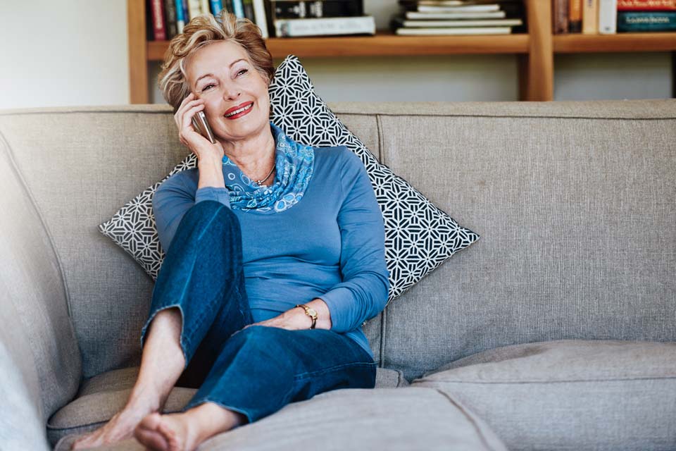 women sitting on lounge talking on the phone