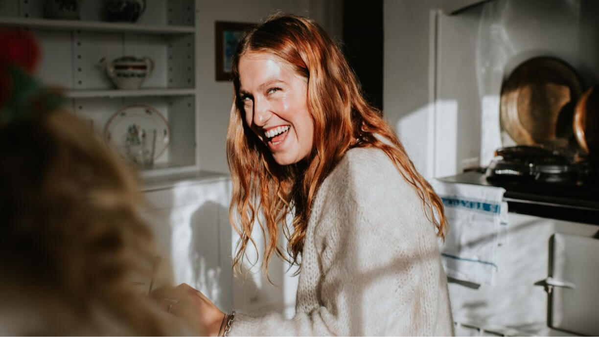 A person smiling warmly indoors.