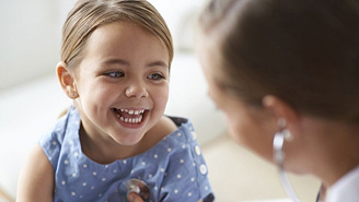 smiling young girl being examined by doctor