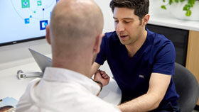 Doctor speaking to and examining patient