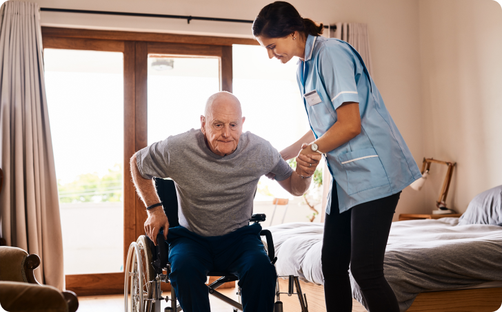 Elderly man being assisted out of wheelchair