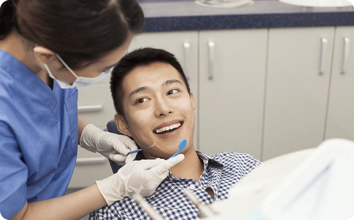 Male patient in dentists chair smiling