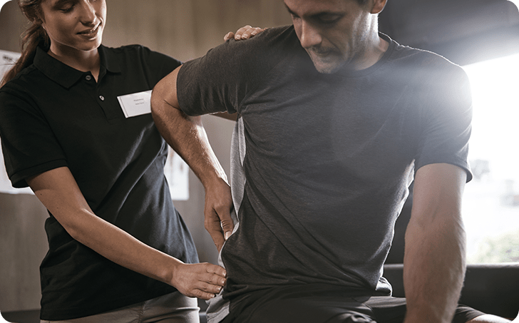 Medical professional examining back of male patient